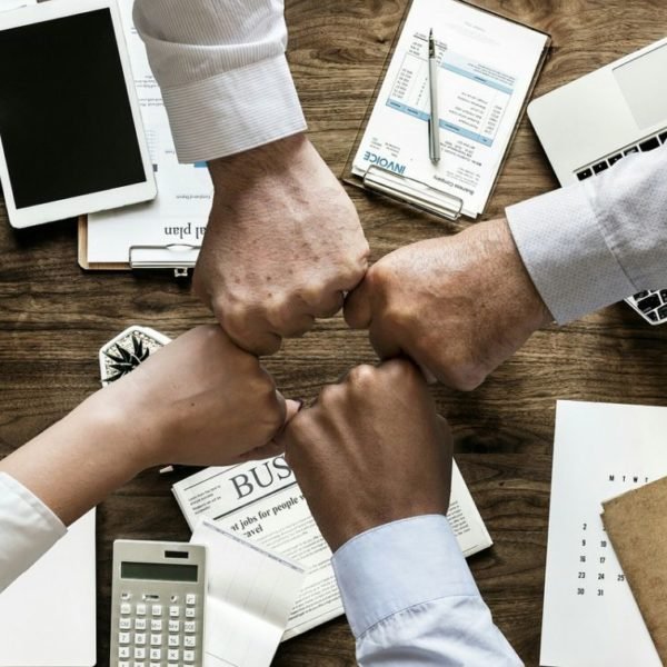 Un Groupe D'hommes D'affaires Joignant Leurs Poings Sur Un Bureau.
