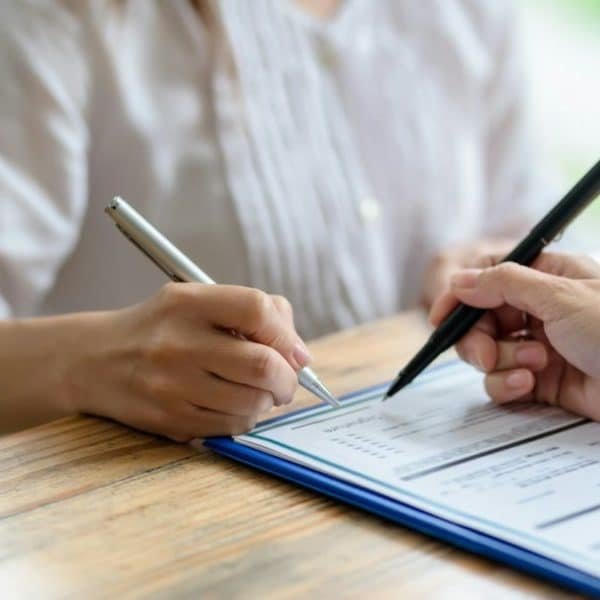 Business people sitting holding pen signing contract paper, lease mortgage.