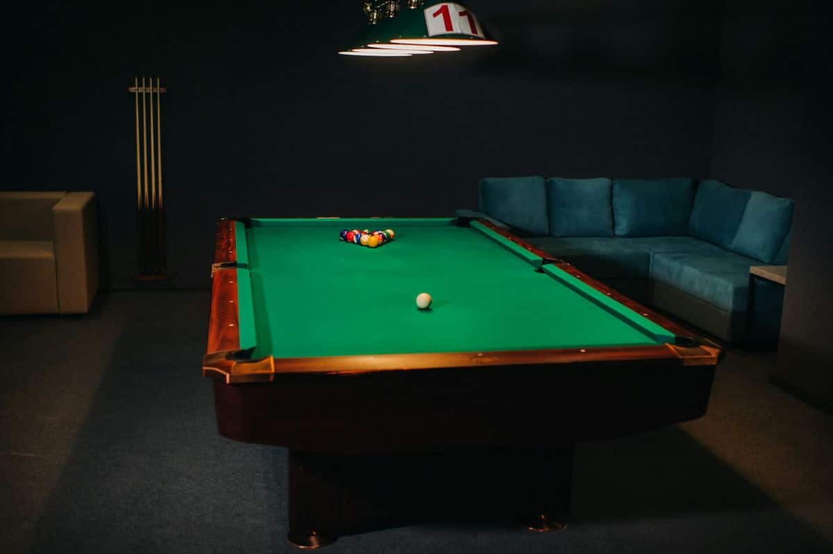 Table de billard avec surface verte et boules dans un club de billard.