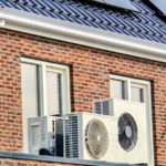 Air Source Heat Pump Unit Installed Outdoors At A Modern Home With Solar Panels In The Netherlands