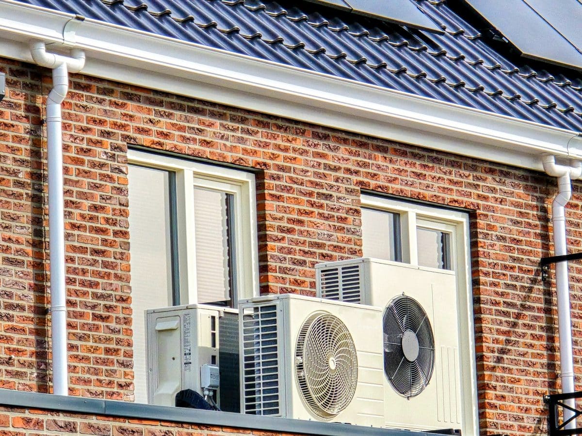 Air Source Heat Pump Unit Installed Outdoors At A Modern Home With Solar Panels In The Netherlands