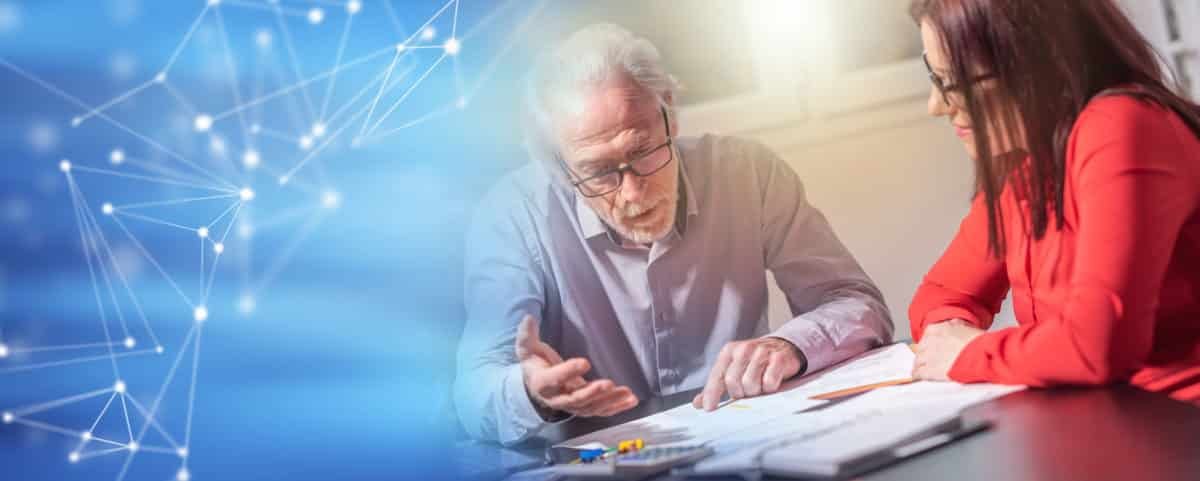 Un Homme âgé Et Une Femme Sont Assis à Une Table Et Discutent De Documents, Avec Un Graphique De Réseau Numérique Bleu Sur Le Côté Gauche De L'image.