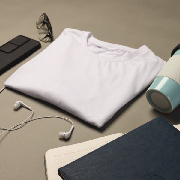 Vue à Plat D'un T Shirt Blanc Plié, D'un Gobelet Réutilisable, De Lunettes, D'un Smartphone, D'écouteurs, D'un Carnet De Notes Et D'un Journal Sur Un Fond Neutre.
