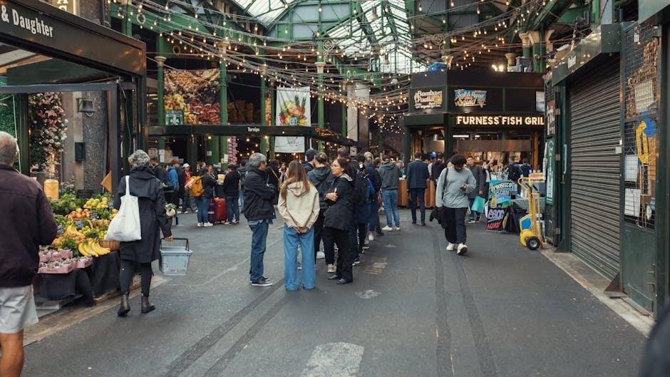 Les Gens Se Promènent Et Font Des Achats Dans Un Marché Couvert Avec Des étals De Nourriture, Des Stands De Produits Frais Et Des Guirlandes Lumineuses.